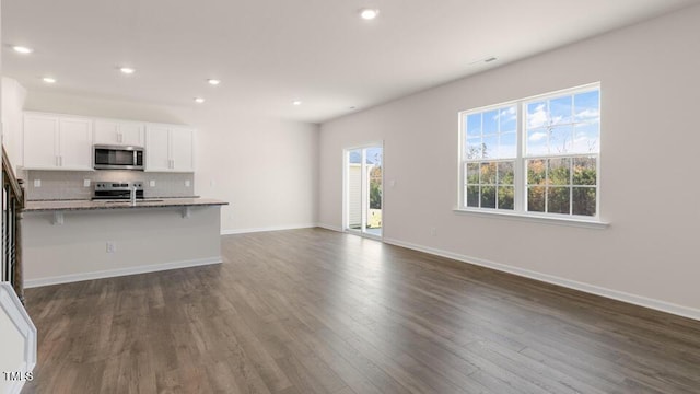 unfurnished living room featuring dark hardwood / wood-style floors