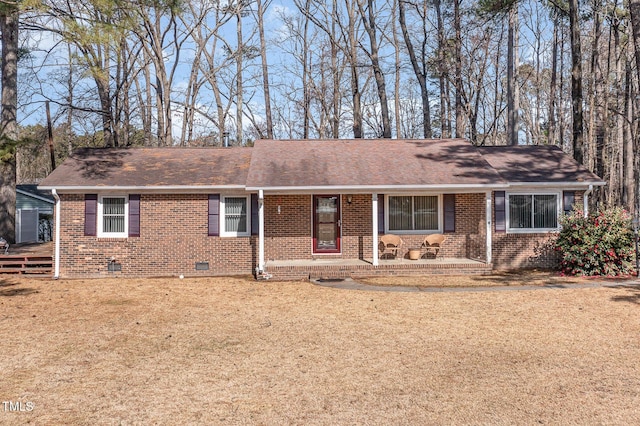 ranch-style house with brick siding, crawl space, a shingled roof, and a front yard