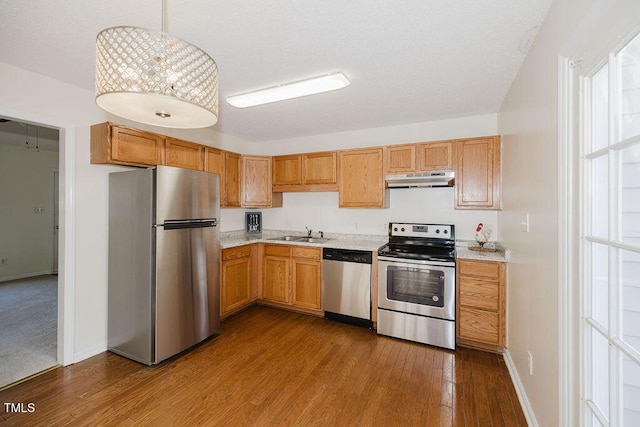 kitchen with appliances with stainless steel finishes, light hardwood / wood-style floors, and sink