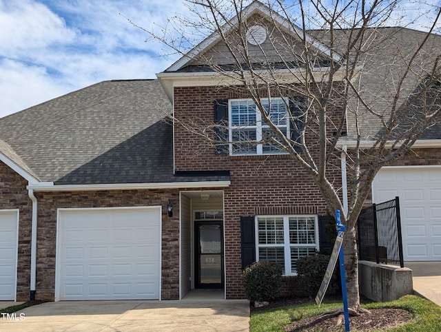 view of front of house with concrete driveway, an attached garage, brick siding, and roof with shingles