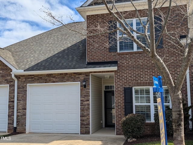 view of front facade with brick siding, an attached garage, and a shingled roof