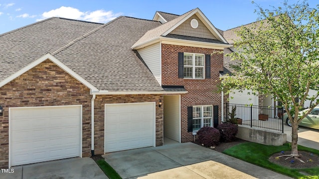 view of front of property featuring a garage, driveway, a shingled roof, and brick siding