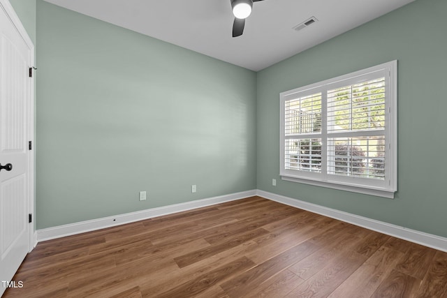 unfurnished room featuring baseboards, a ceiling fan, wood finished floors, and visible vents