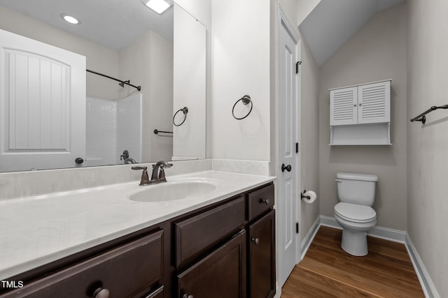 full bathroom featuring wood finished floors, vanity, walk in shower, baseboards, and toilet