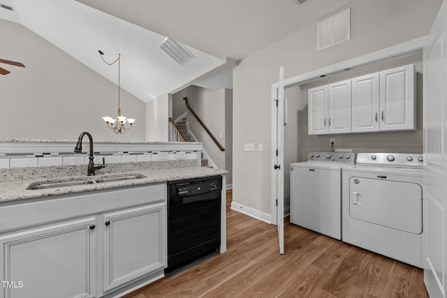 interior space featuring a sink, washer and clothes dryer, visible vents, light wood-style floors, and cabinet space