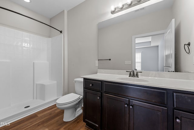 full bathroom featuring wood finished floors, vanity, toilet, and walk in shower