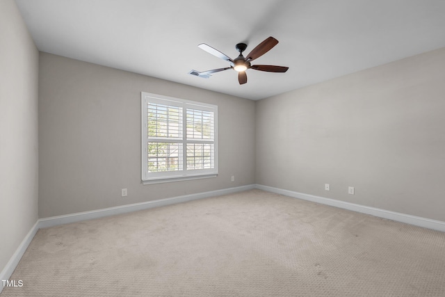 carpeted empty room featuring visible vents, a ceiling fan, and baseboards