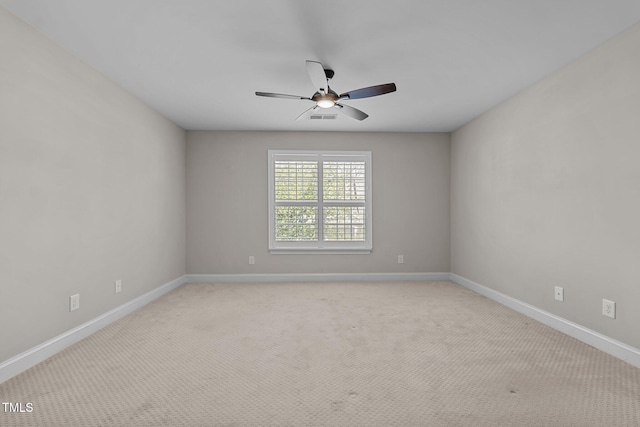 spare room with baseboards, a ceiling fan, and visible vents