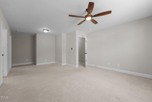 unfurnished room with visible vents, a ceiling fan, baseboards, and light carpet
