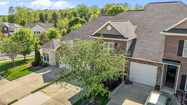 view of front facade with a residential view, a shingled roof, and stone siding