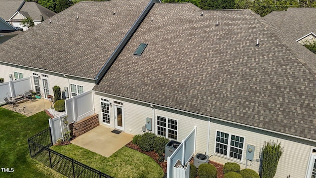 exterior space featuring a fenced backyard, roof with shingles, and a patio