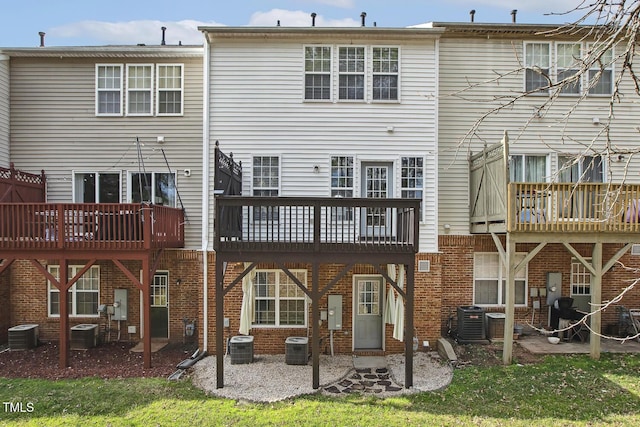 rear view of property featuring a patio, cooling unit, and brick siding