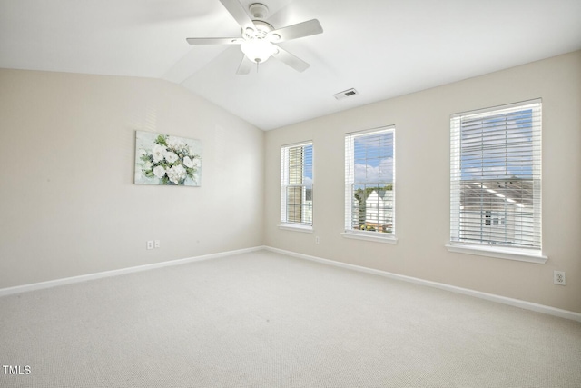 unfurnished room with light colored carpet, visible vents, vaulted ceiling, ceiling fan, and baseboards