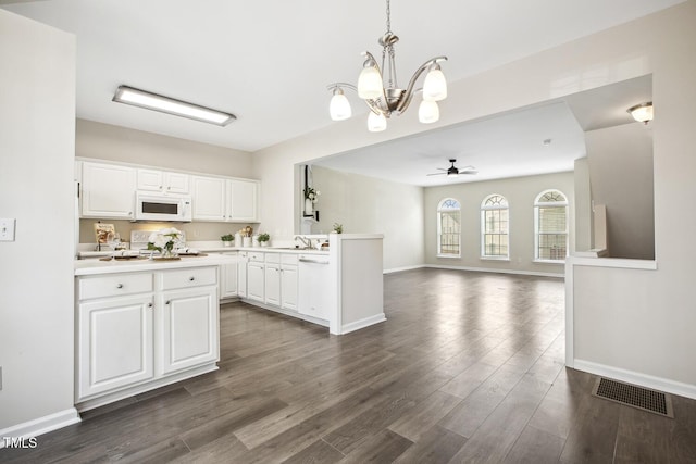 kitchen with light countertops, visible vents, white cabinets, white appliances, and a peninsula