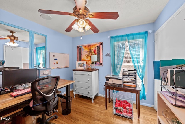 home office featuring light wood-style floors, a wealth of natural light, and ceiling fan