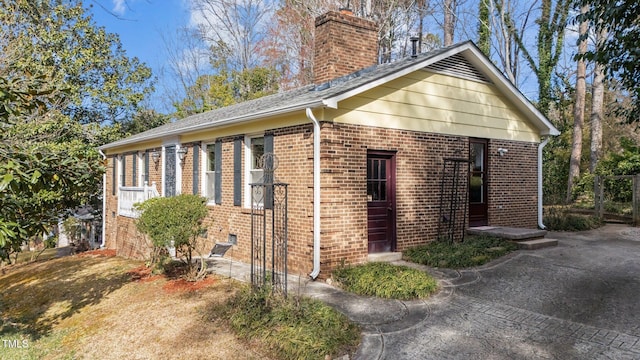 view of side of property featuring brick siding and a chimney