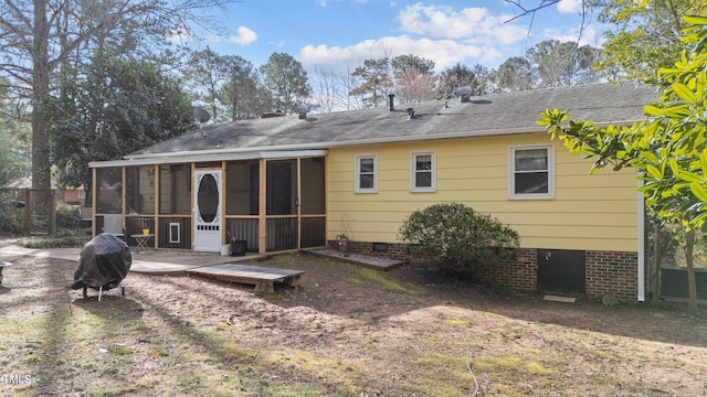 back of property with crawl space, a sunroom, and roof with shingles