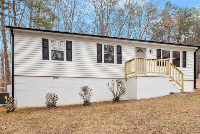 view of front of home with central AC and a front lawn