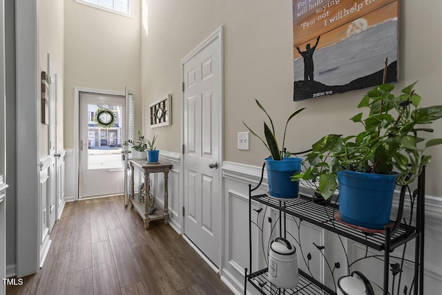 entryway with dark wood-style flooring and wainscoting