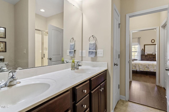 bathroom with double vanity, a stall shower, a sink, and connected bathroom