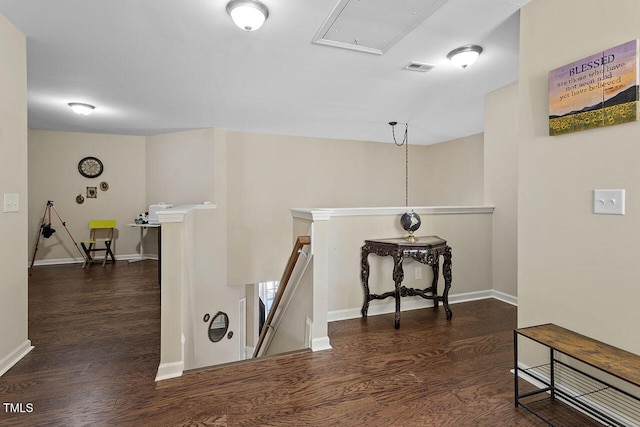 hallway featuring visible vents, attic access, an upstairs landing, wood finished floors, and baseboards