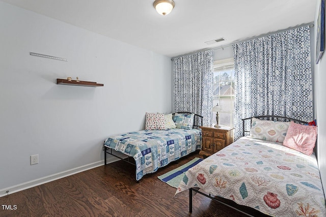 bedroom featuring visible vents, baseboards, and wood finished floors