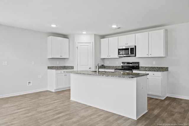 821 Tori Dr, Spring Lake, NC 28390 - kitchen with appliances with stainless steel finishes, a sink, baseboards, dark stone countertops, and white cabinetry