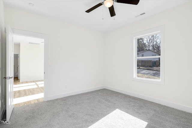 spare room with light colored carpet and ceiling fan