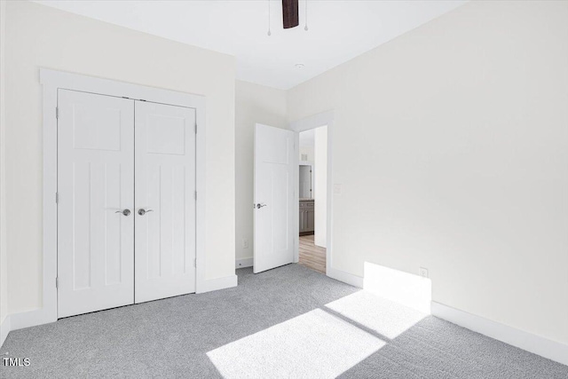 unfurnished bedroom with light colored carpet, a closet, and ceiling fan