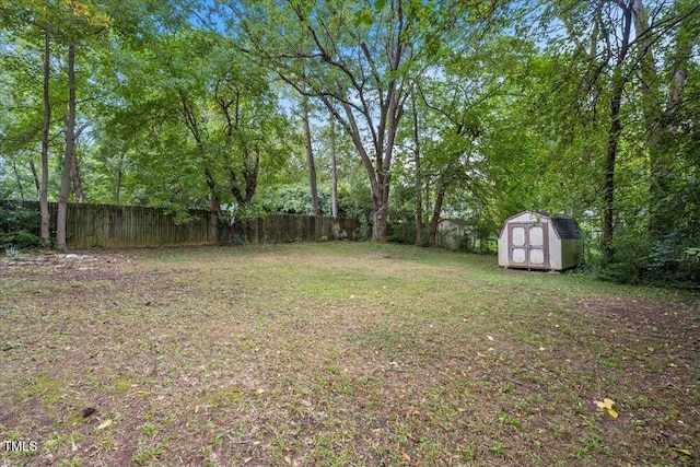 view of yard with an outbuilding, fence, and a storage shed