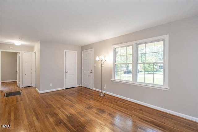 empty room with baseboards and hardwood / wood-style flooring