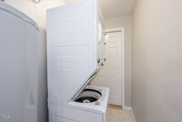 laundry area featuring stacked washer and dryer, laundry area, and baseboards