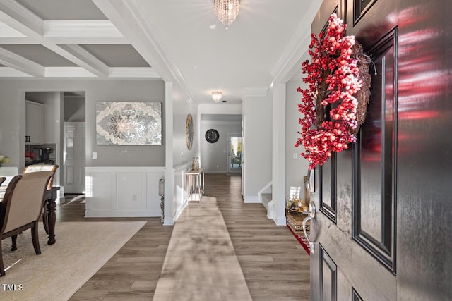 entryway featuring hardwood / wood-style flooring, ornamental molding, coffered ceiling, and beam ceiling