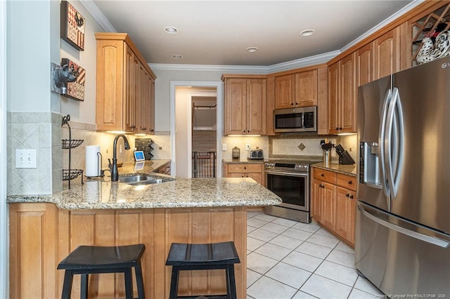 kitchen featuring stainless steel appliances, a kitchen bar, kitchen peninsula, and sink