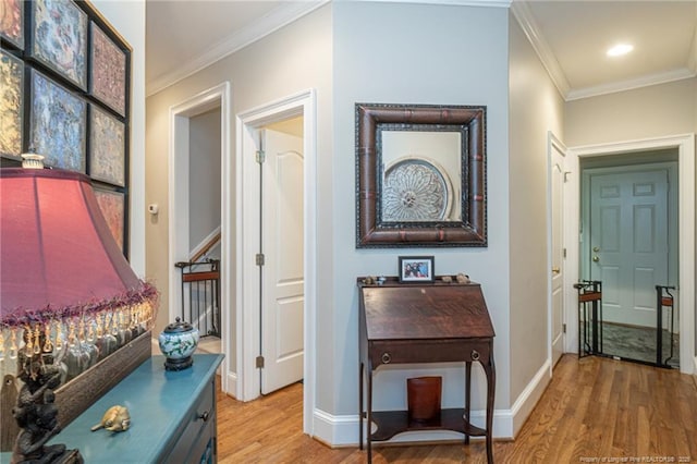 corridor with hardwood / wood-style floors and ornamental molding