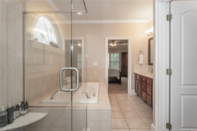 bathroom featuring tile patterned floors, ornamental molding, vanity, and tiled tub