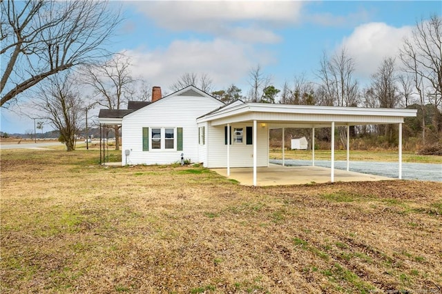 exterior space featuring a carport and a yard