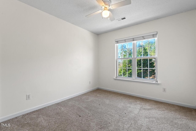 spare room with carpet floors, visible vents, a textured ceiling, and baseboards