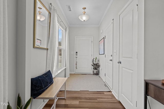 doorway with ornamental molding and wood-type flooring