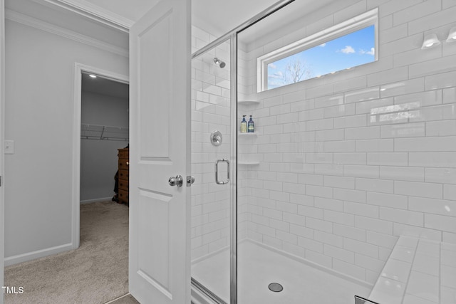 bathroom featuring ornamental molding and a shower with door