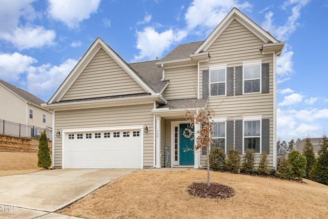 traditional-style house with a shingled roof, concrete driveway, and an attached garage