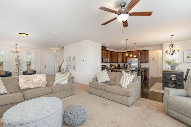 living room with recessed lighting, visible vents, baseboards, and ceiling fan with notable chandelier