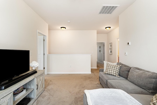 living room featuring light colored carpet, visible vents, and baseboards