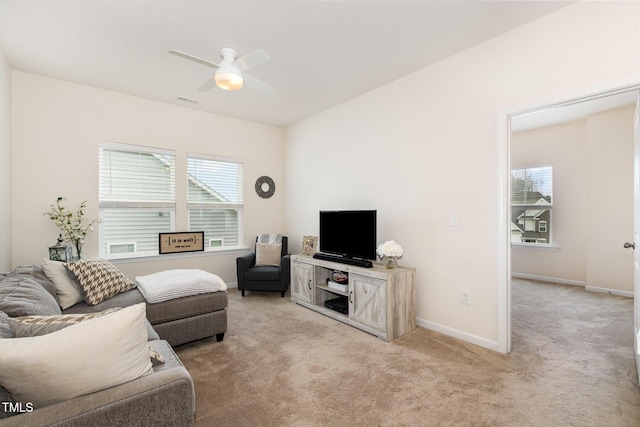 living area with a ceiling fan, light colored carpet, visible vents, and baseboards