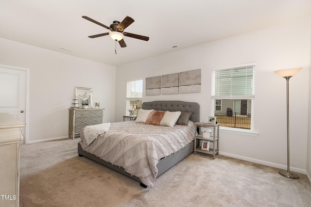 bedroom featuring light carpet, ceiling fan, visible vents, and baseboards