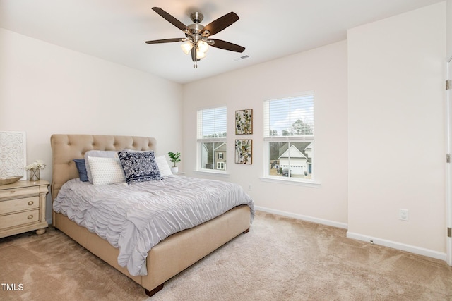 bedroom featuring baseboards, visible vents, ceiling fan, and light colored carpet