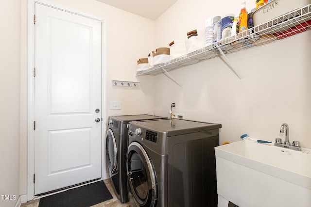 laundry room with laundry area, a sink, and washer and clothes dryer