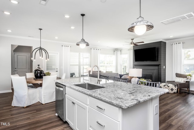 kitchen featuring white cabinetry, sink, hanging light fixtures, and a center island with sink