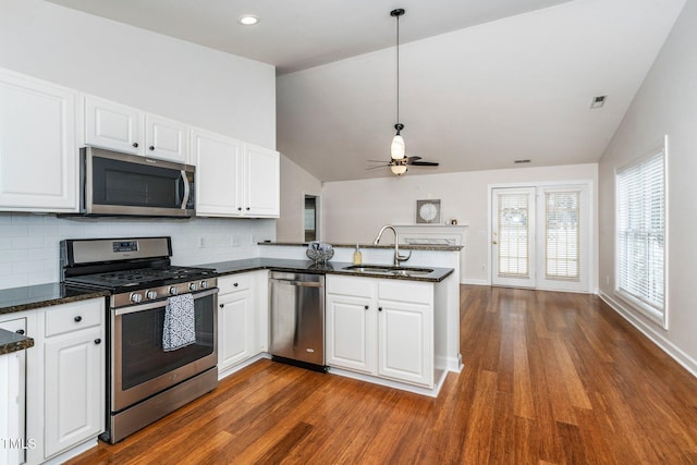 kitchen with stainless steel appliances, white cabinetry, a sink, and a peninsula