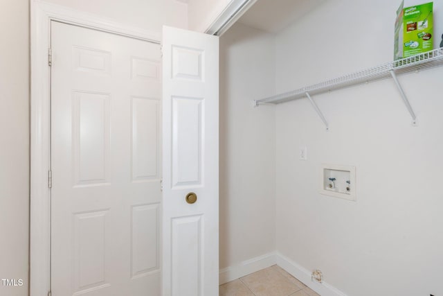 clothes washing area with hookup for a washing machine, light tile patterned floors, baseboards, and laundry area